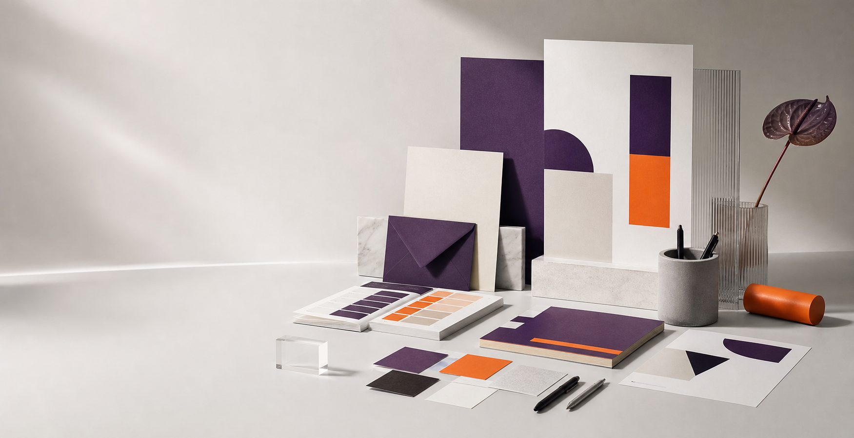 Materiais de identidade visual com papeis, amostras de cor e mockups em um estudio minimalista.